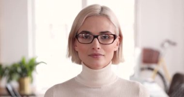 Smiling young businesswoman looking at camera in office, closeup portrait