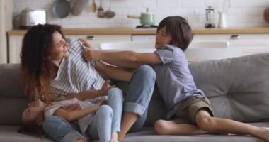 Happy young woman baby sitter nanny playing with children siblings.