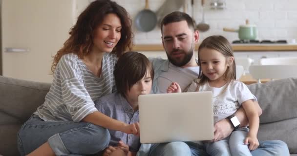 Uśmiechnięta czteroosobowa rodzina korzystająca z laptopa, zakupy w domu. — Wideo stockowe