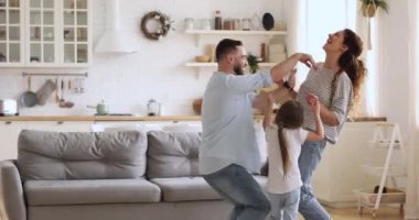 Overjoyed millennial couple playing with laughing little children siblings.