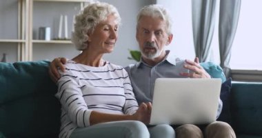 Serious middle aged man explaining new computer software to wife.