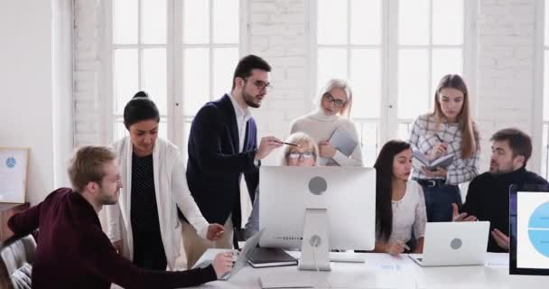 Diversi gruppi di lavoro discutono il piano di progetto lavorando insieme sui computer — Video Stock