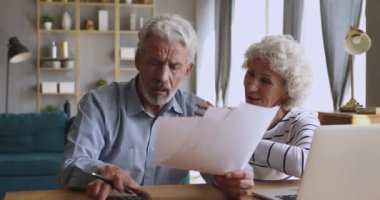 Happy middle aged hoary woman supporting worrying mature husband.