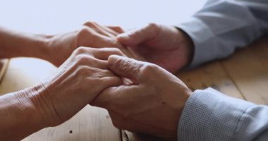 Romantic middle aged married couple stroking hands.