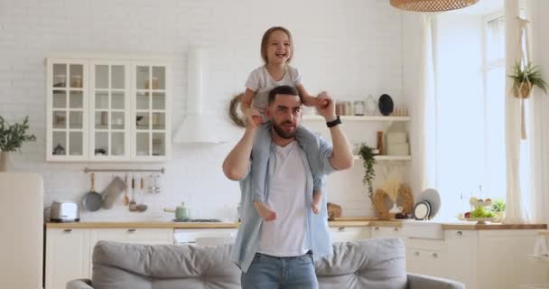 Sonriente joven papá llevando a su pequeña hija emocionada, bailando juntos . — Vídeos de Stock