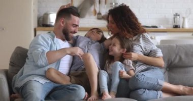 Affectionate bonding family of four enjoying leisure time.