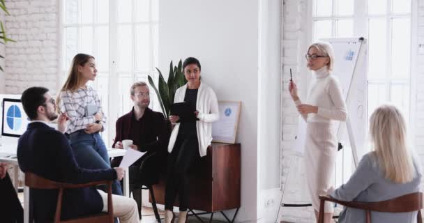 Businesswoman leader teaching diverse business team giving flip chart presentation — 비디오