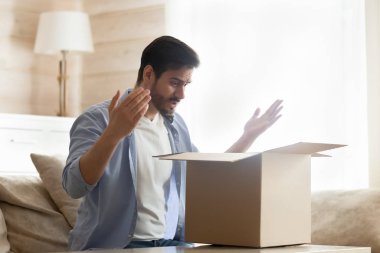 Frustrated male customer unpack box disappointed with order