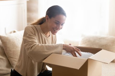 Happy female customer unpack internet order shopping online