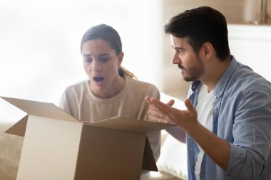 Frustrated couple open package disappointed with internet shopping