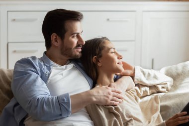Happy couple relax cuddle at home dreaming