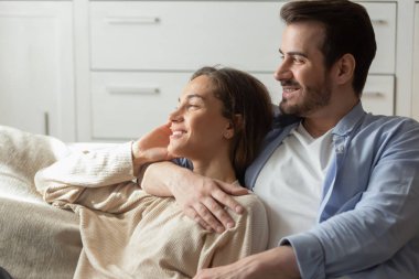 Happy young couple relax look in distance dreaming