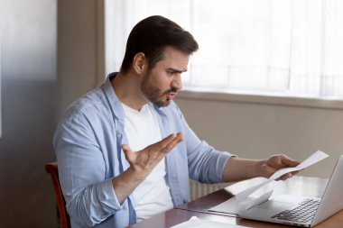 Frustrated man shocked by bad news in mail correspondence