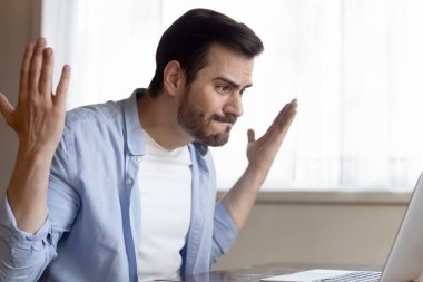 Mad Caucasian man having computer problems working on laptop