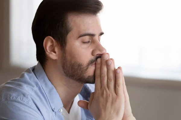Hopeful man with hands in prayer ask for best luck — Stockfoto