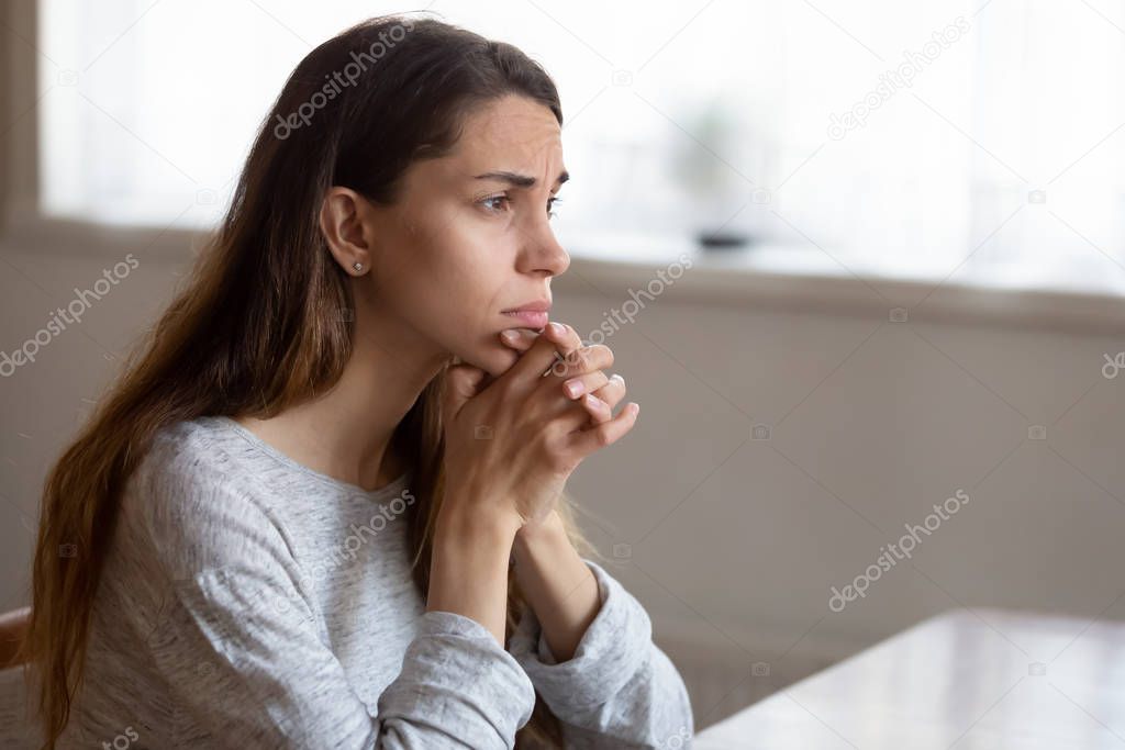 Sad young woman look in distance thinking of problems