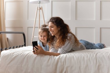 Happy bonding family watching funny cartoons on smartphone.