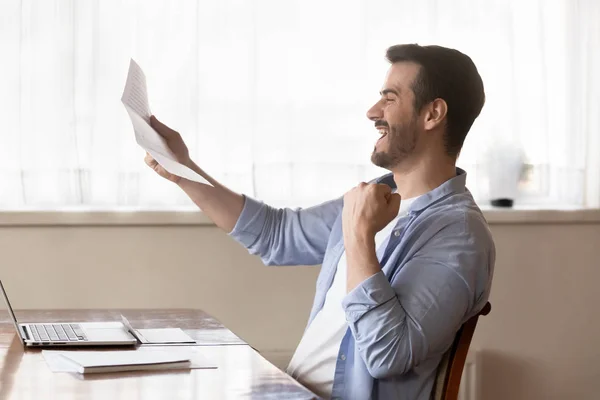 Excited male worker get pleasant news in letter — Stock Photo, Image