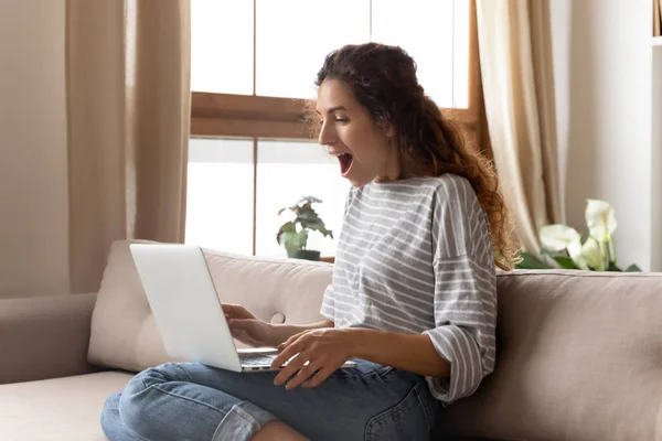 Mujer joven sorprendida mirando el monitor de computadora con la boca abierta . — Foto de Stock