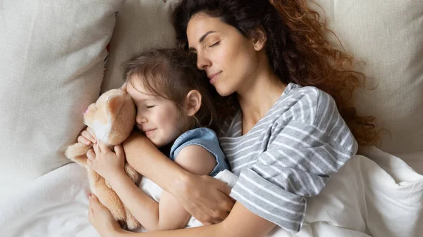 Tranquillo giovane madre dormire con calma piccola figlia . — Foto Stock