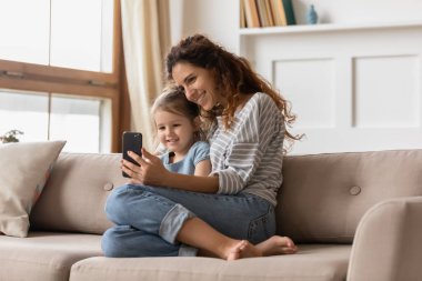 Smiling affectionate family of two posing for smartphone selfie.