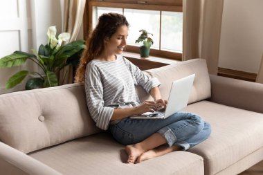 Happy woman shopping in internet store or web surfing.