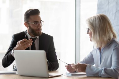 Arabian and european business partners negotiating in modern boardroom