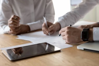 Diverse businesspeople working together develop tactics closeup desk and documents