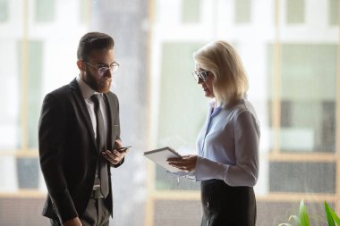 Diverse colleagues met at hallway discuss current business issues