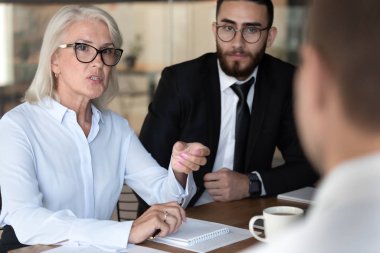 Negotiations lead by middle-aged businesswoman talking with client