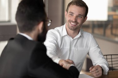 Diverse business partners start negotiations shaking hands express respect