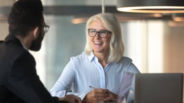 Female ceo met with company client diverse businesspeople negotiating indoors