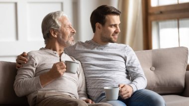 Two generations family enjoying free time with cup of tea.
