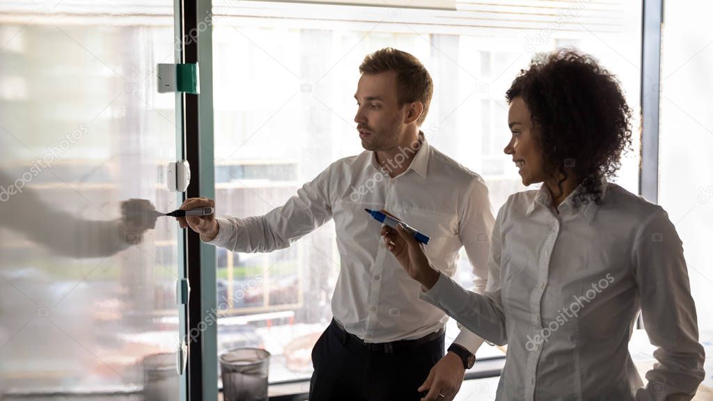 African and caucasian entrepreneurs writing on white board presentation