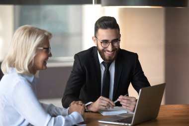 Diverse cheerful client and company representative at meeting in office