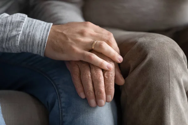 Young man put hand on wrinkled older senior fathers hand. — Stock Photo, Image