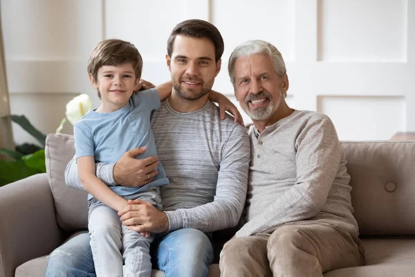 Glückliche drei Generationen männliche Familie ruht auf Couch. — Stockfoto