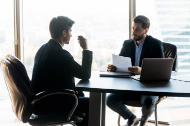 Serious businessman holding cv document listening new job candidate.
