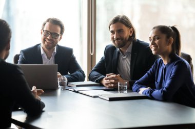 Applicant sitting in front happy HR businessmen and businesswoman speaking.