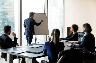 Confident businessman writing on flip charts presentation new project.