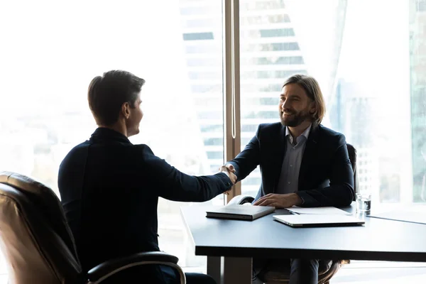 Bearded businessman in suit shaking hands with job seeker. — Stock Photo, Image