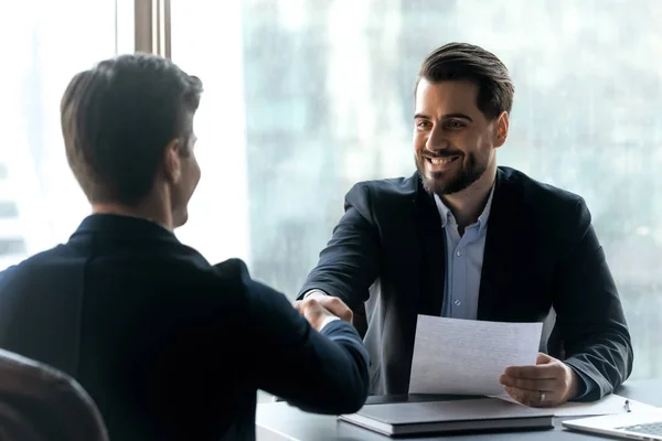 Sonriente hombre de negocios barbudo en traje estrechando la mano con el buscador de empleo . —  Fotos de Stock