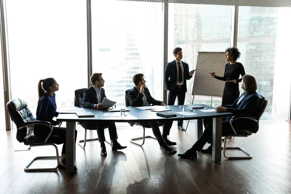 Mujer de negocios afroamericana y hombre de negocios rotafolios presentación nuevo proyecto . — Foto de Stock