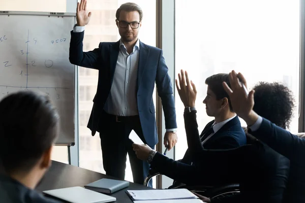 Selbstbewusster Geschäftsmann-Mentor hebt mit Kollegen-Frage im Sitzungssaal die Hand. — Stockfoto