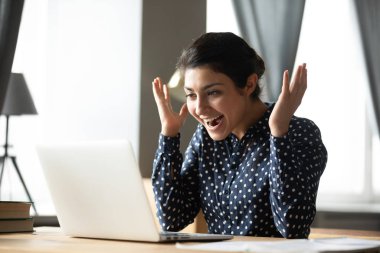 Excited indian girl amazed with good online news