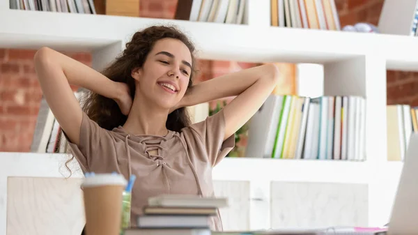 Horizontal photo smiling girl student relaxing during break in library — Stok fotoğraf