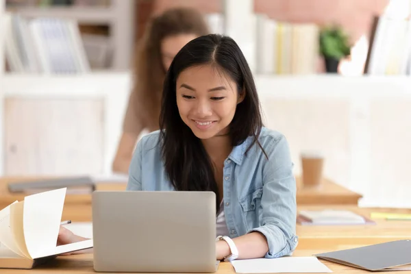 Sorrindo asiática estudante do sexo feminino estudando, usando laptop em sala de aula — Fotografia de Stock