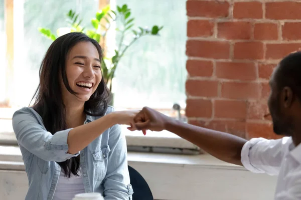 Souriant asiatique femme d'affaires avec afro-américain collègue poings bosse — Photo