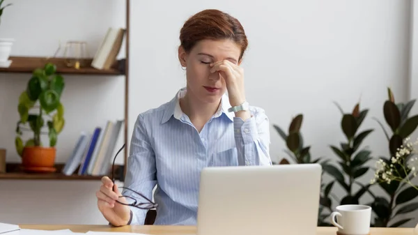 Mujer de negocios cansada que sufre de tensión en los ojos, masaje de puente nasal —  Fotos de Stock