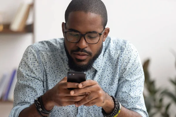 Empresário afro-americano usando smartphone, olhando para a tela — Fotografia de Stock